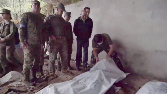 ハピロン容疑者らの遺体を確認するロレンザナ国防相(中央)ら=大統領府の発表映像から