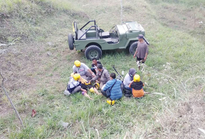 転落したジープとヘルメットを着けた乗客ら=スレマン県BPBD提供
